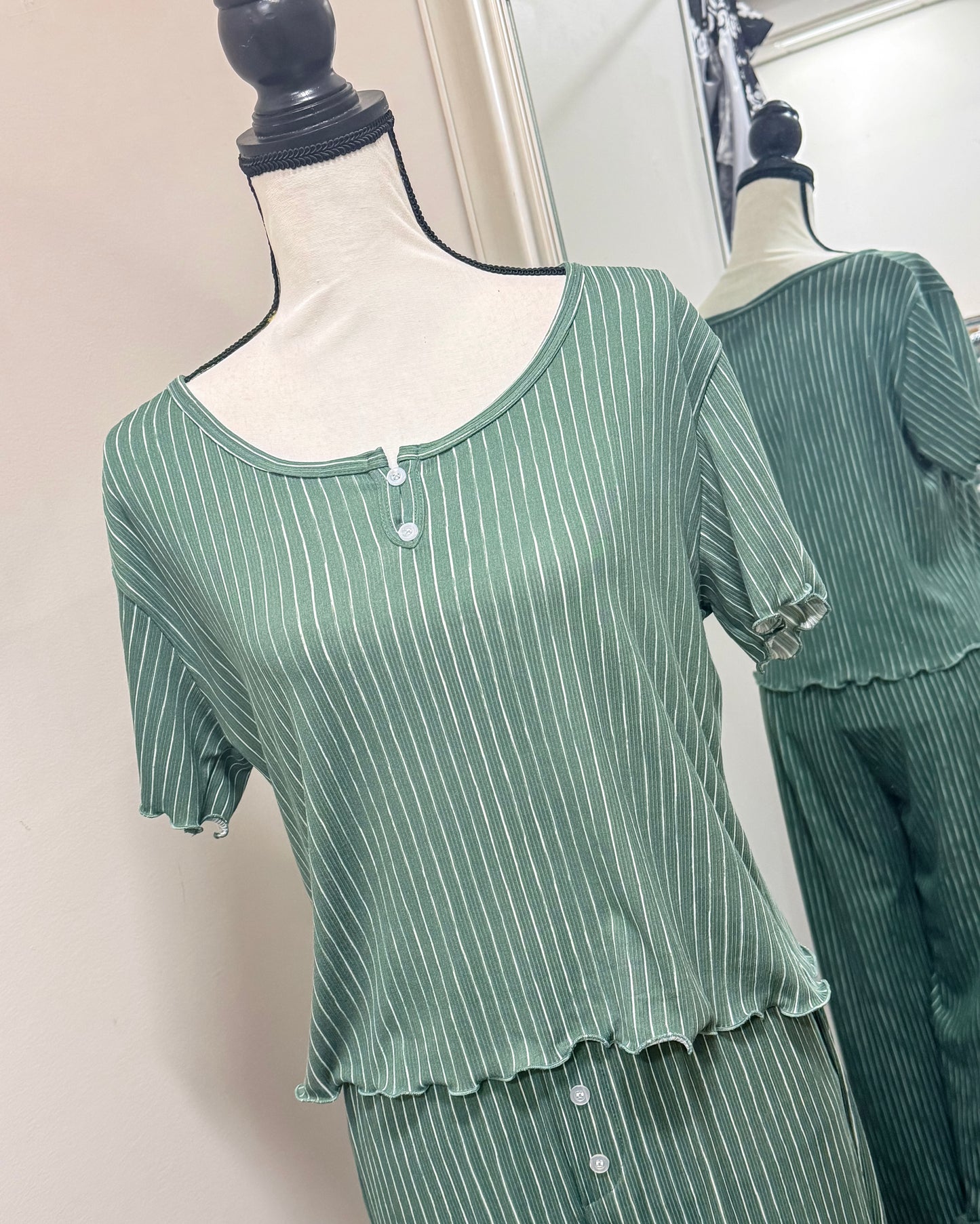 Green striped pajama set on a mannequin against a neutral background
