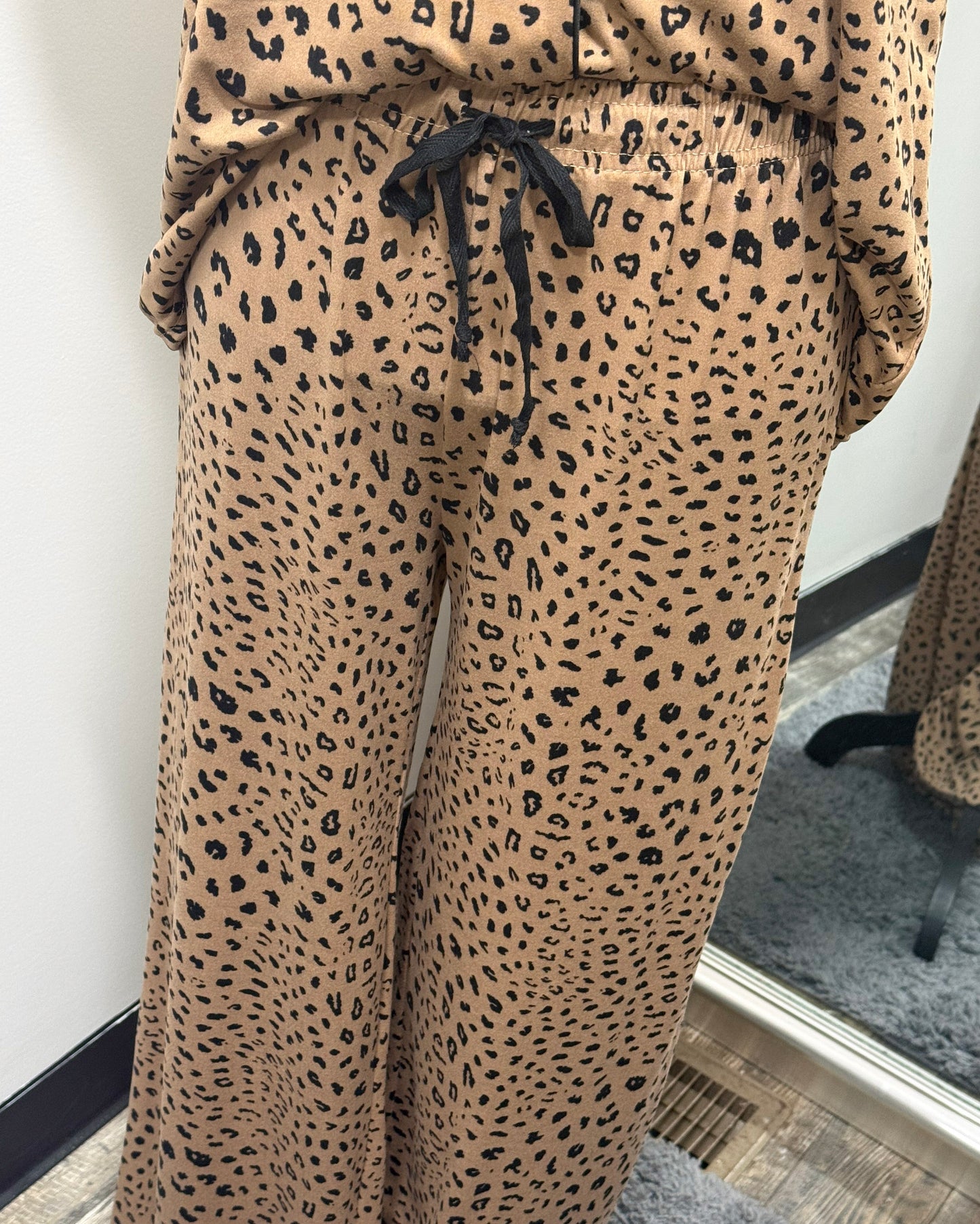 Leopard print pajama pants with a drawstring waist on a plain background