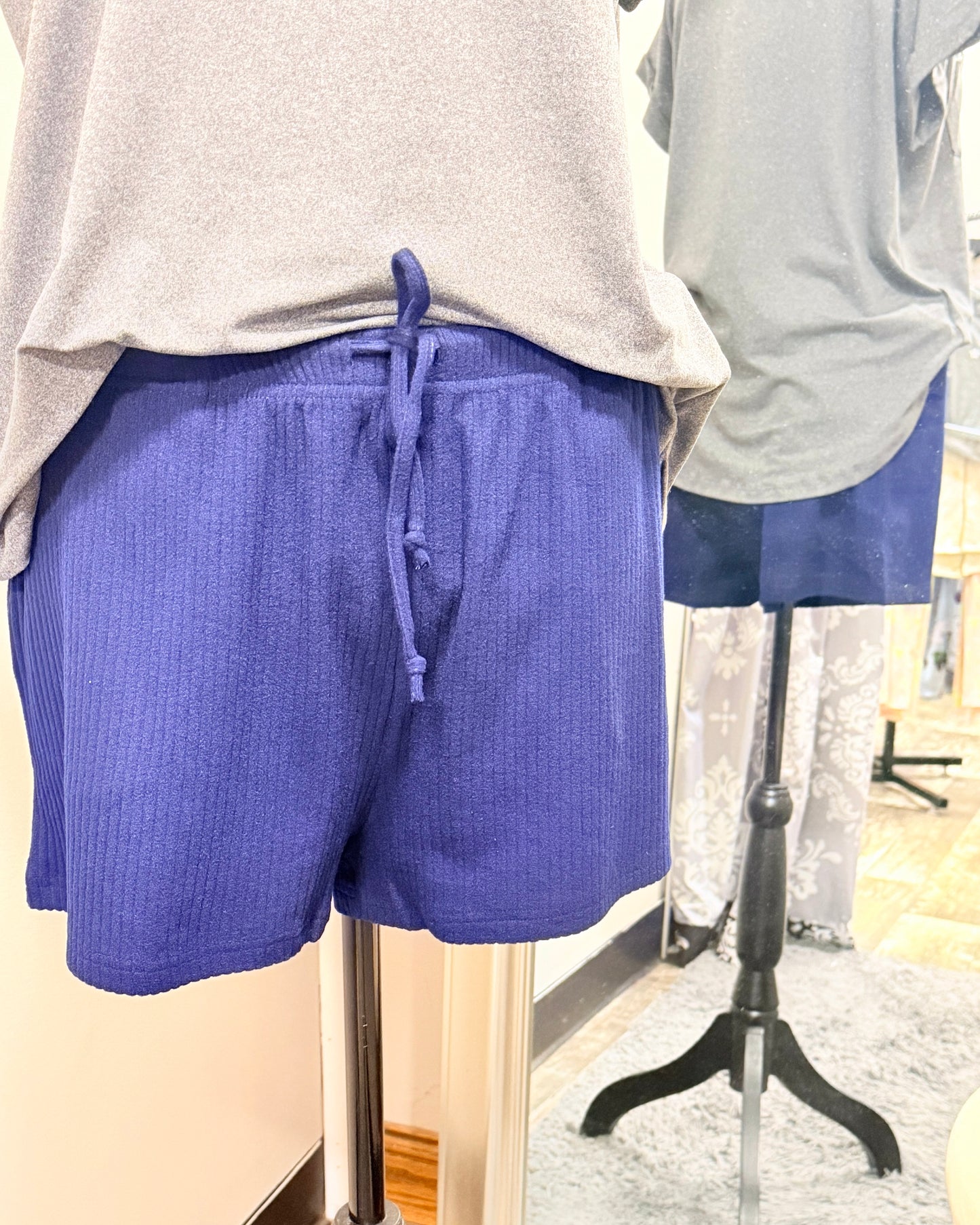 Blue shorts on a mannequin with a gray top in a store setting