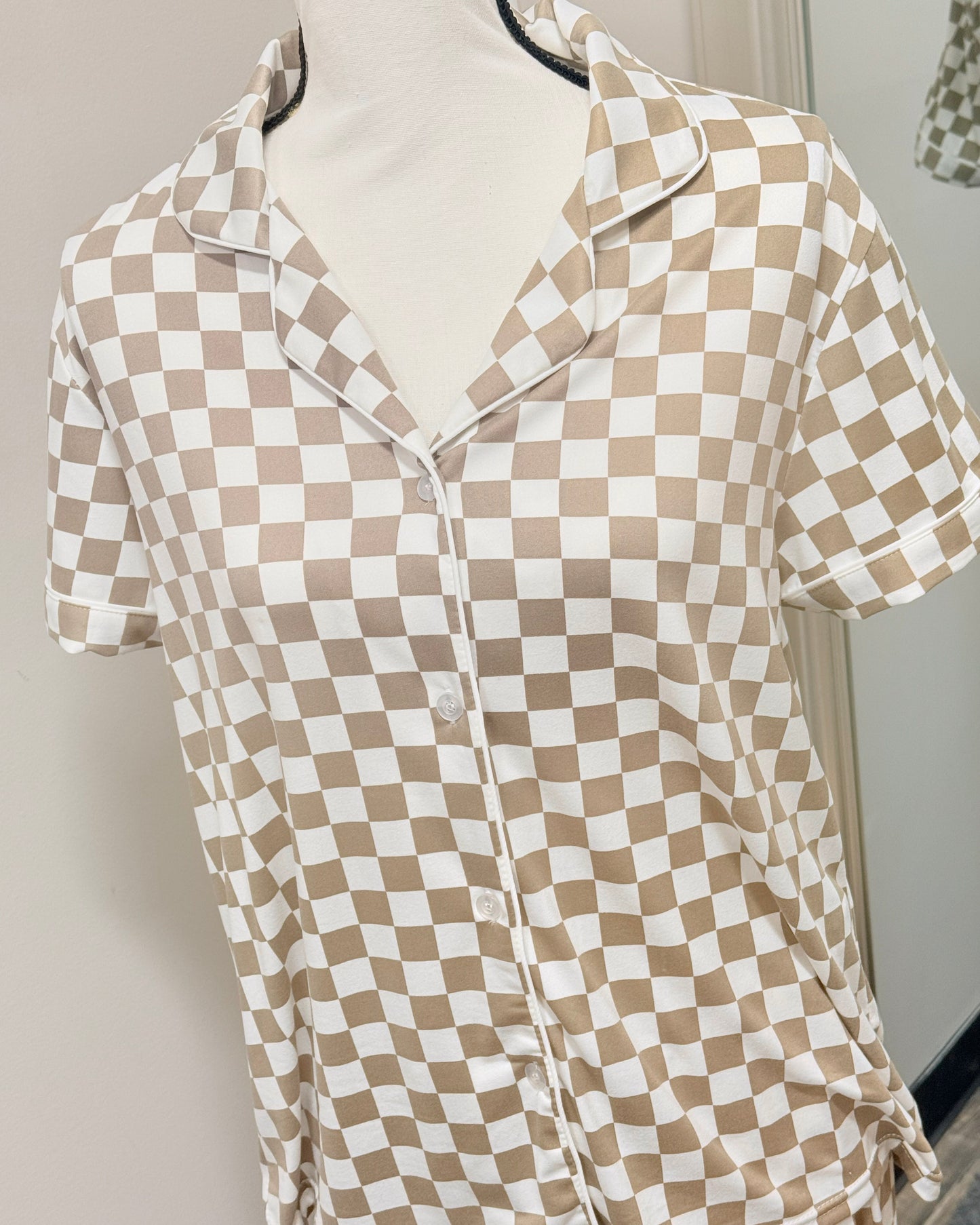Checkered pajama shirt on a mannequin against a neutral background