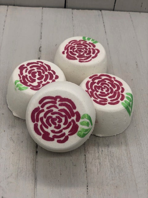 Rose scented white bubble bombs painted on the top with red rose petals and a green leaf