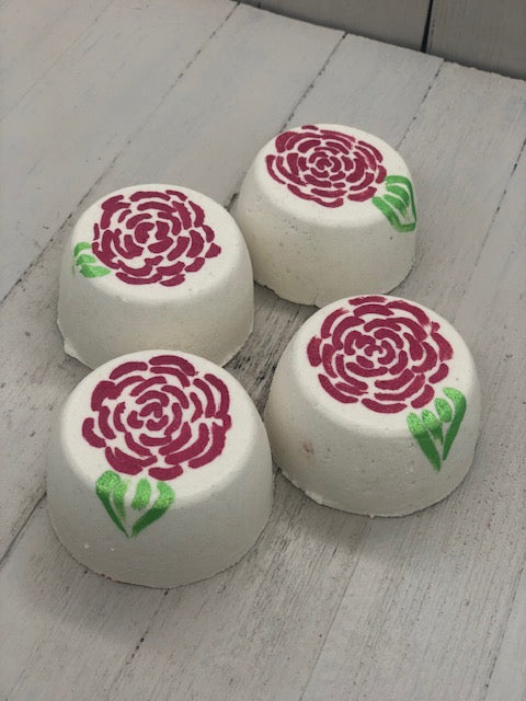 Rose scented white bubble bombs painted on the top with red rose petals and a green leaf