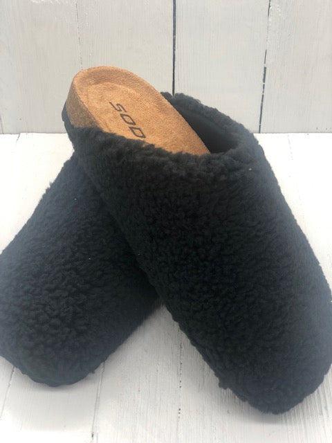 Black sherpa slippers with cork bottoms.