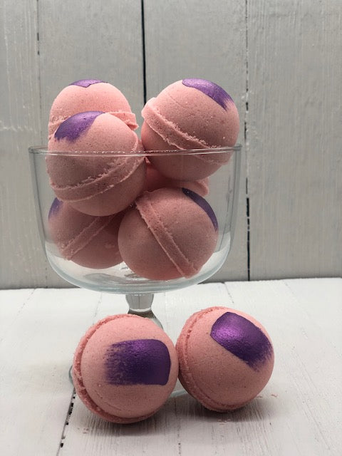 Pink bath bombs with a purple paint streak.