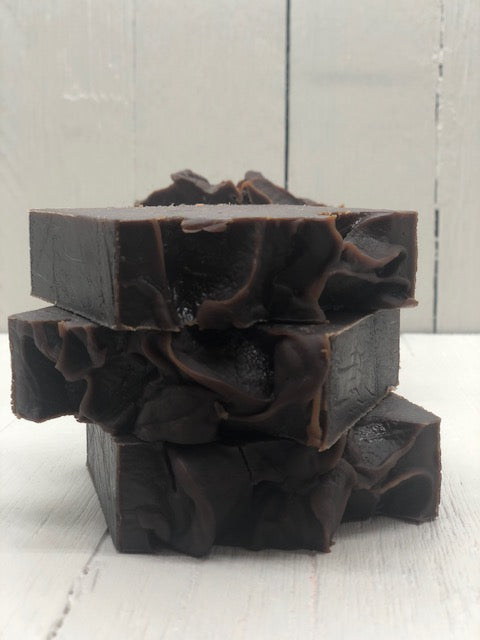 Dark brown bar of soap with a swirled top.