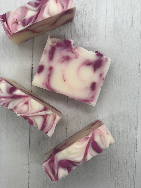 A white soap bar with swirls of bright pink.