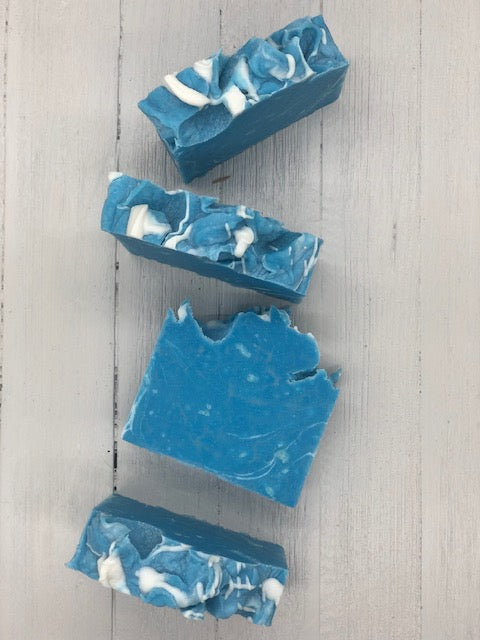 An ocean blue soap bar with white swirls and a fluffy top.