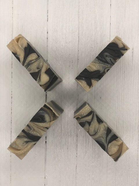 A khaki colored soap bar with dark brown swirls.