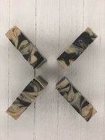 A khaki colored soap bar with dark brown swirls.