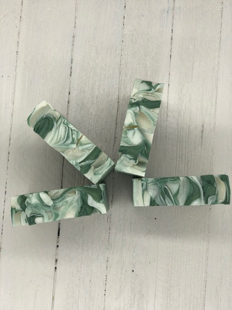 A white bar of soap with dark green swirls.