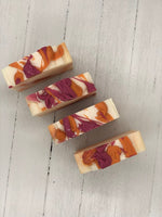A white soap bar with pink and orange swirls.