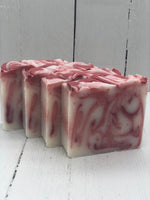 A white bar of soap with red swirls.